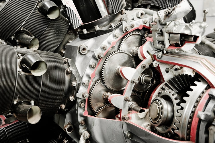 Close-up view of the internal gears, cogs, and components inside a cutaway section of a complex industrial machine or engine.