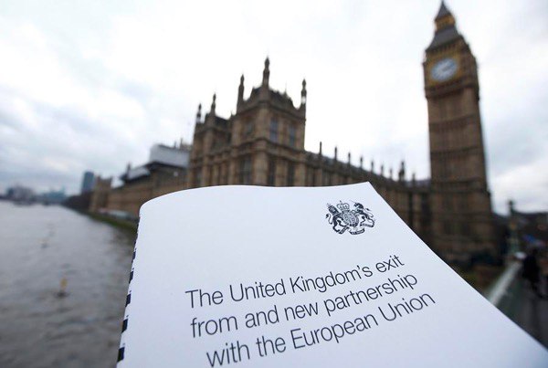 A document titled “The United Kingdom’s exit from and new partnership with the European Union” held in front of the Houses of Parliament and Big Ben in London.